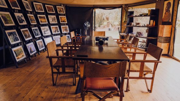 Photography studio tent with framed prints and a long table